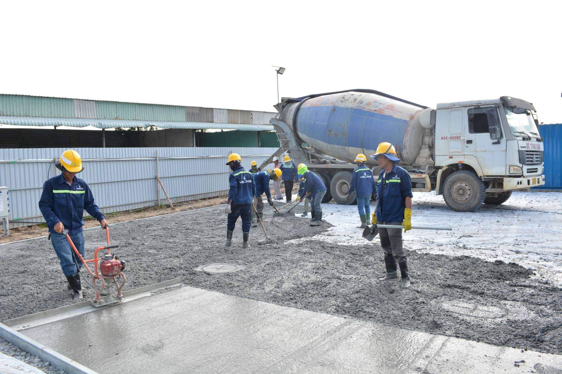 Beton støbes til kantsten ved indkørsel